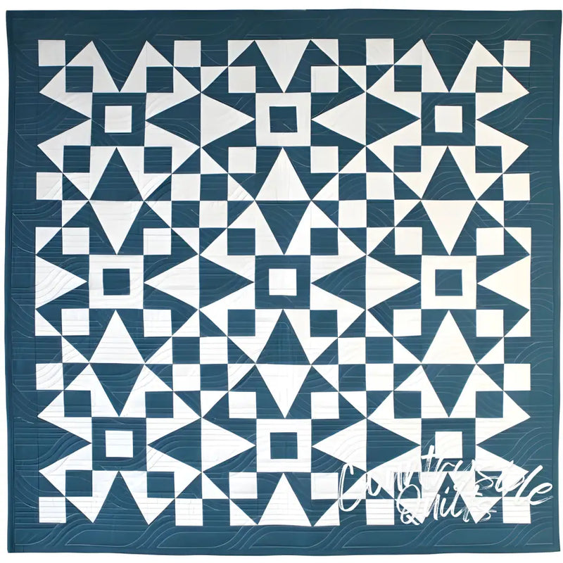 Geometric patterned quilt in teal blue and white from Art East Quilting Propeller Quilt Pattern