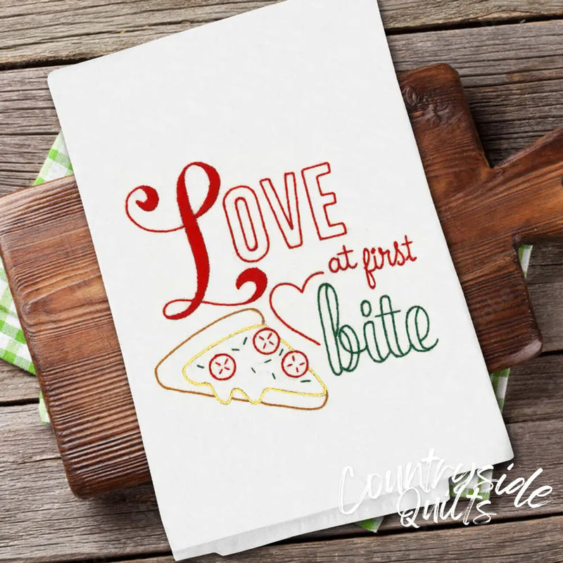 White kitchen towel with red Love at First Bite text and pizza design for Aunt Martha’s All-American Treats