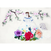 Hand-embroidered figure in white dress on Aunt Martha’s® Lovely Foursome Pillowcases with colorful flowers