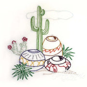 Hand-embroidered desert scene by Aunt Martha’s featuring saguaro cactus and pottery