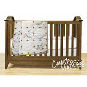 Wooden baby crib with Retro Flower Print blanket, showcasing Aunt Martha’s quilting fabric